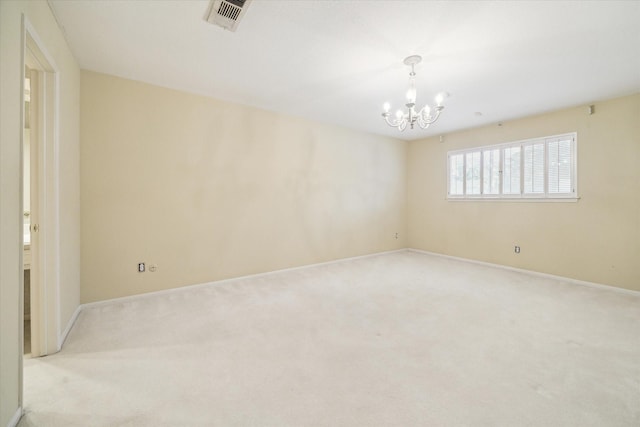 carpeted empty room featuring a notable chandelier