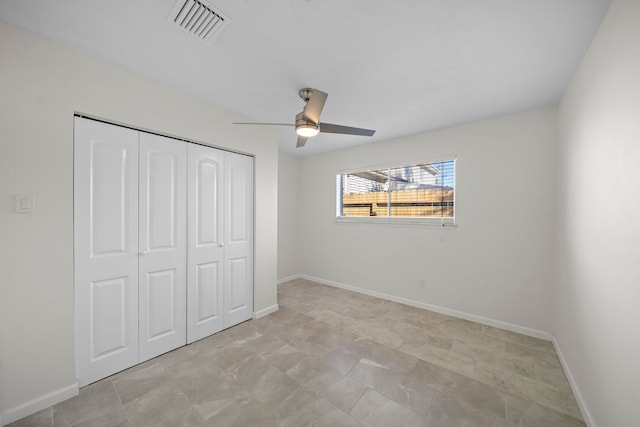 unfurnished bedroom with ceiling fan and a closet