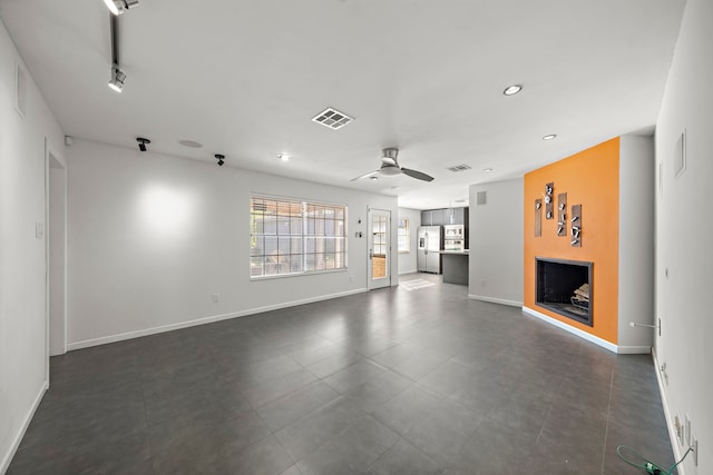 unfurnished living room featuring rail lighting and ceiling fan