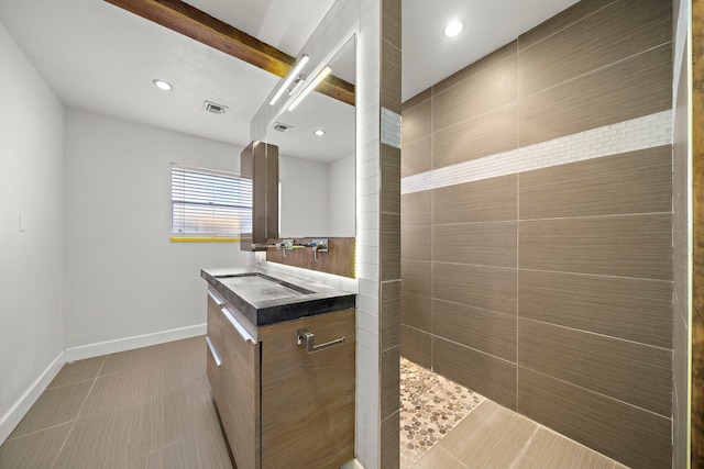 bathroom with beamed ceiling, vanity, a shower, and tile patterned floors