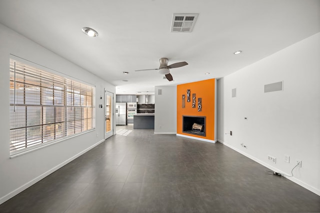 unfurnished living room featuring ceiling fan