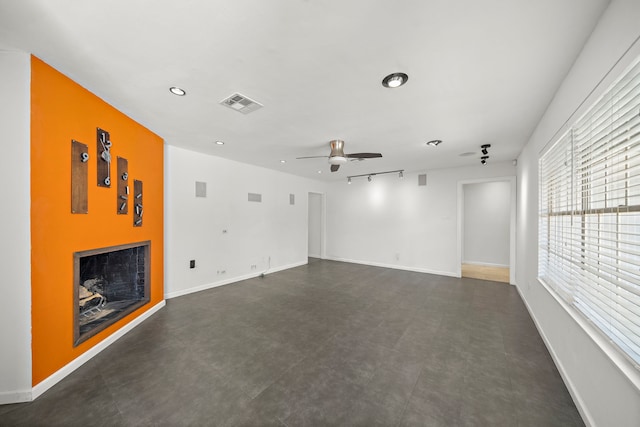 unfurnished living room with rail lighting and ceiling fan