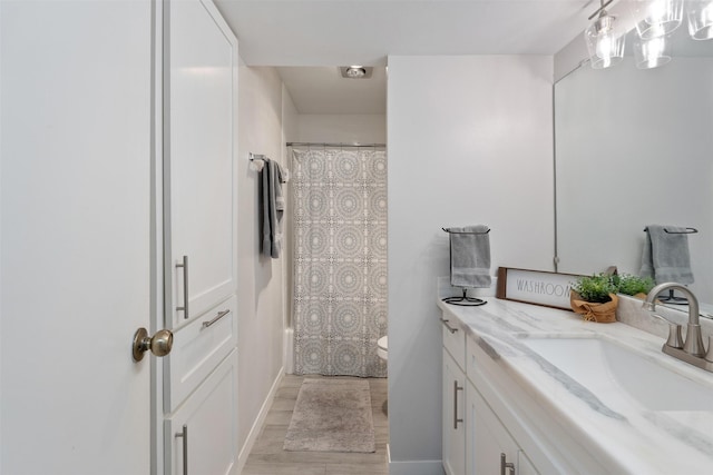 bathroom featuring hardwood / wood-style flooring, vanity, and toilet