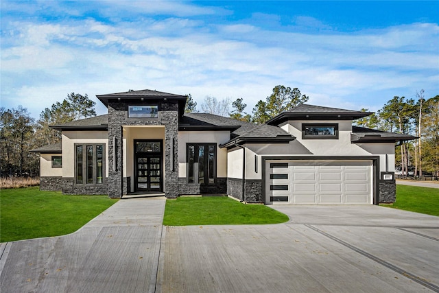 prairie-style home featuring a garage, a front yard, and french doors