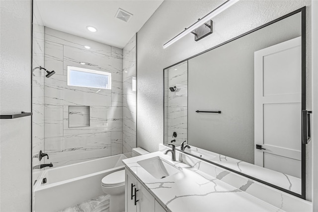 full bathroom featuring tiled shower / bath combo, vanity, and toilet