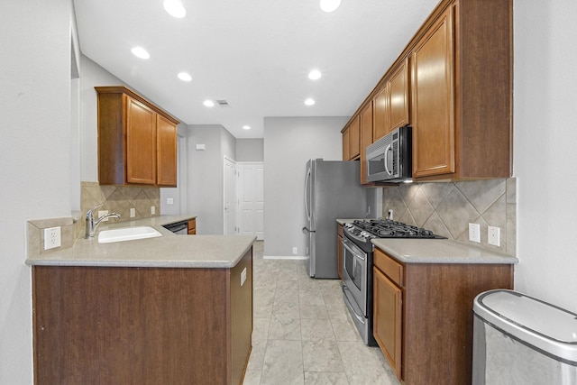 kitchen featuring light countertops, brown cabinets, a peninsula, stainless steel appliances, and a sink