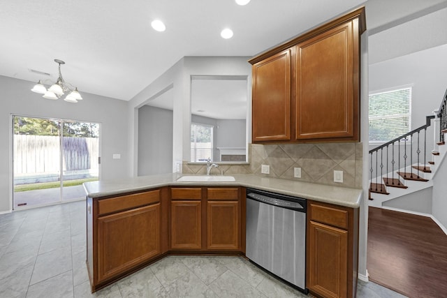 kitchen with a sink, stainless steel dishwasher, brown cabinetry, and light countertops