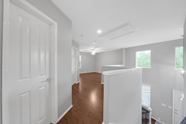 hall with an upstairs landing, dark wood finished floors, and baseboards