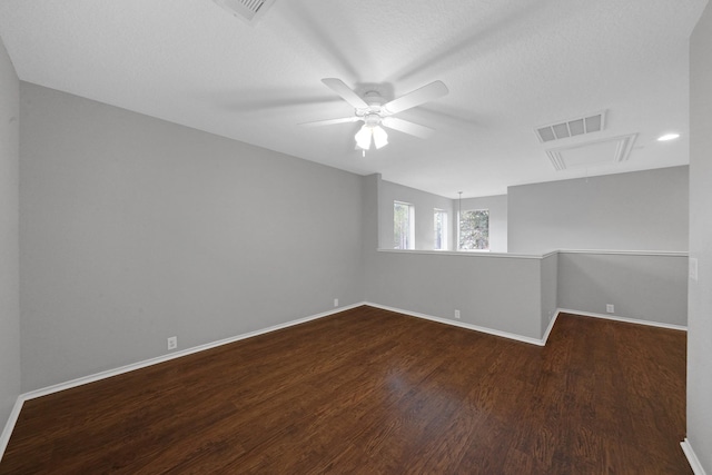 unfurnished room featuring attic access, baseboards, visible vents, and dark wood-type flooring