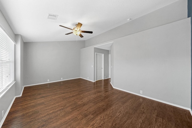 empty room with visible vents, baseboards, ceiling fan, and dark wood-style flooring