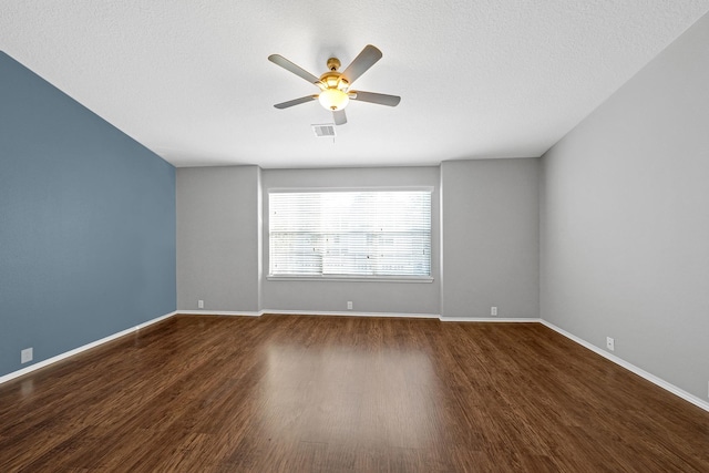 unfurnished room featuring a ceiling fan, wood finished floors, visible vents, and baseboards