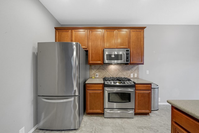 kitchen with light countertops, brown cabinets, backsplash, and stainless steel appliances