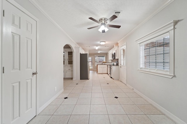 hall featuring light tile patterned floors and crown molding