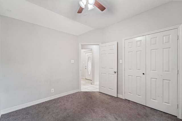 unfurnished bedroom featuring vaulted ceiling, light colored carpet, a closet, and ceiling fan