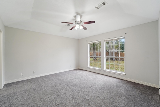 spare room with a tray ceiling, carpet floors, and ceiling fan