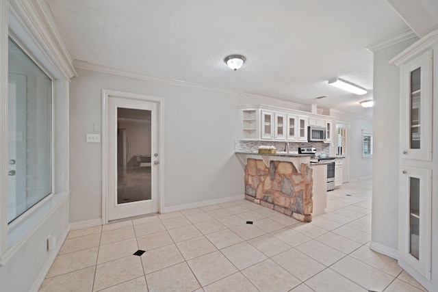 kitchen featuring a breakfast bar, crown molding, white cabinetry, appliances with stainless steel finishes, and kitchen peninsula