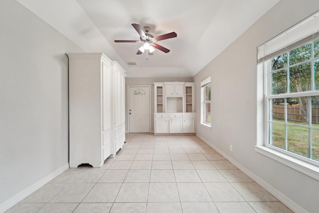 tiled empty room with vaulted ceiling and ceiling fan