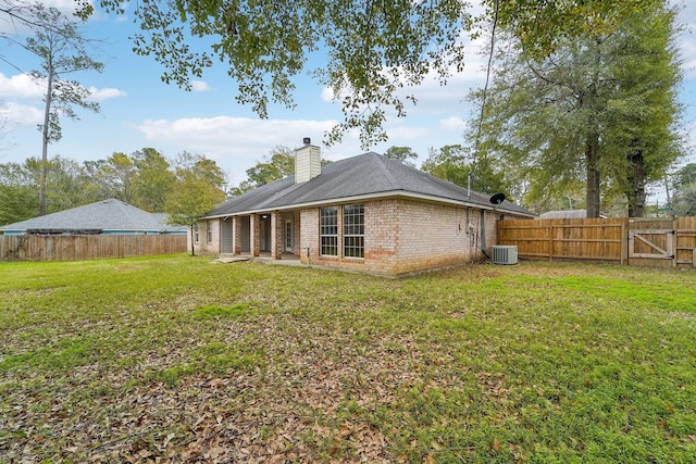 back of property with a yard and central AC unit