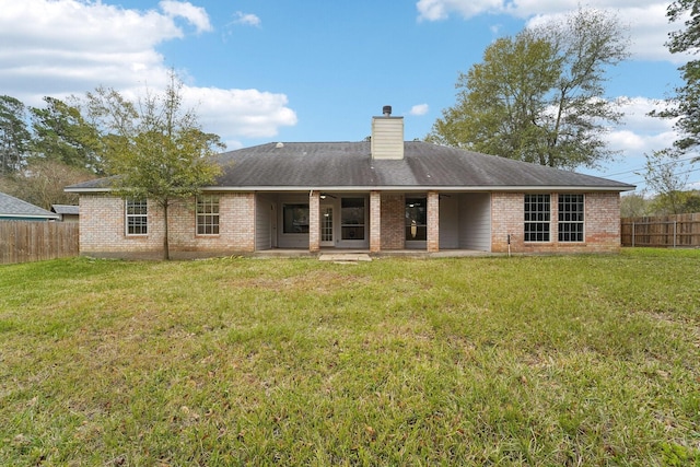 rear view of property with a yard and a patio