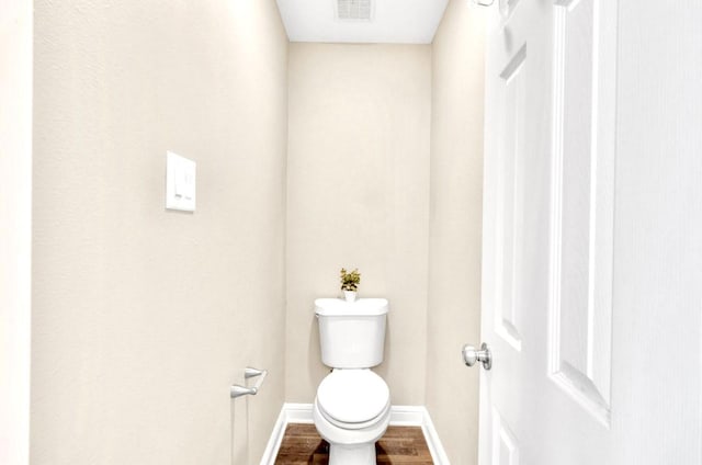 bathroom with hardwood / wood-style floors and toilet