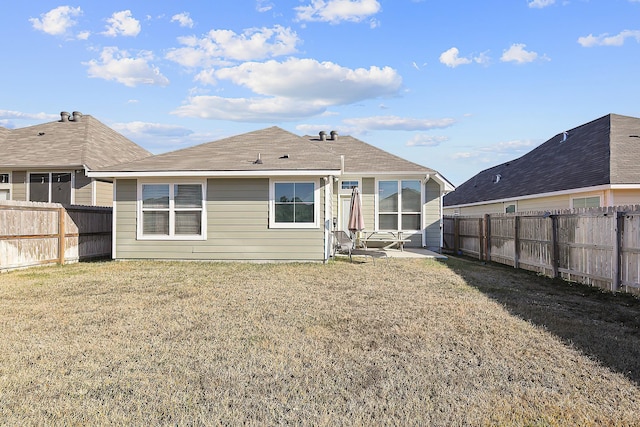 back of house with a patio area and a lawn