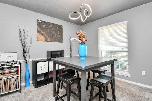 carpeted dining room featuring a textured ceiling