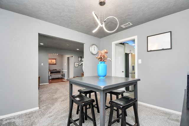 dining space featuring carpet and a textured ceiling