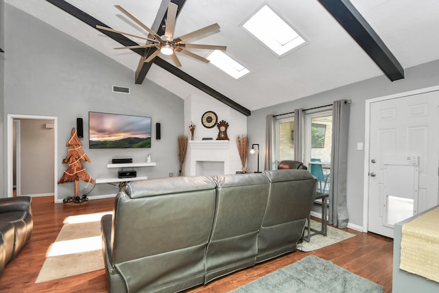 living room with lofted ceiling with skylight, dark hardwood / wood-style floors, and ceiling fan