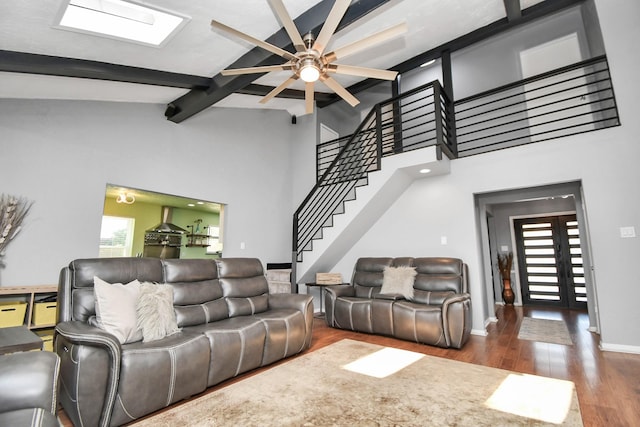 living room featuring lofted ceiling with skylight, ceiling fan, and dark hardwood / wood-style flooring