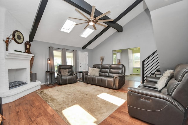 living room with hardwood / wood-style flooring, beam ceiling, and a wealth of natural light