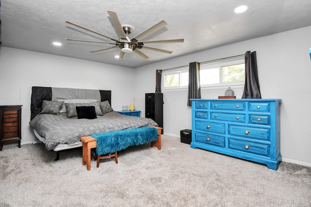 carpeted bedroom featuring ceiling fan and a textured ceiling