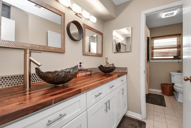 bathroom featuring tile patterned floors, toilet, and vanity