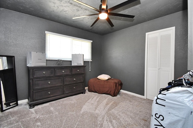 carpeted bedroom featuring ceiling fan and a closet