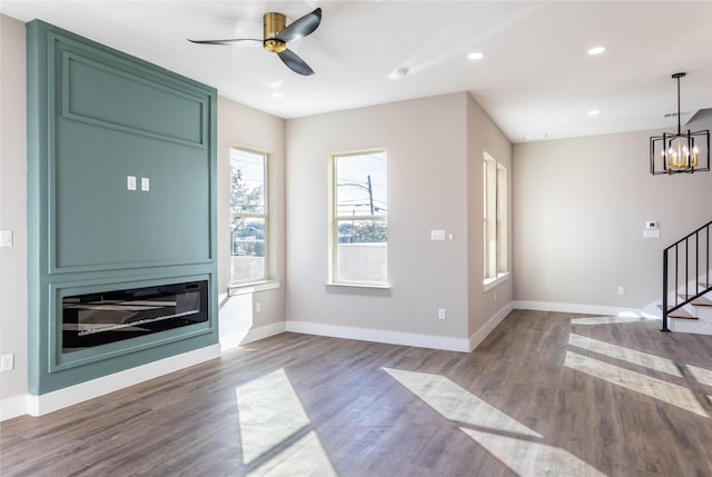 unfurnished living room with recessed lighting, stairway, baseboards, and wood finished floors