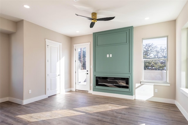 unfurnished living room featuring recessed lighting, wood finished floors, and baseboards