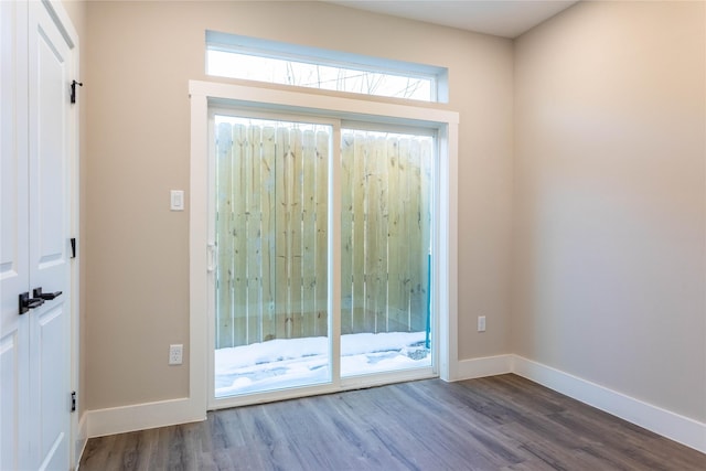 doorway to outside with wood finished floors and baseboards