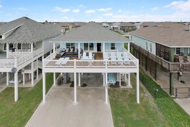 rear view of house featuring a carport and a yard