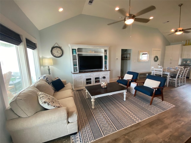 living room with ceiling fan, dark wood-type flooring, and high vaulted ceiling