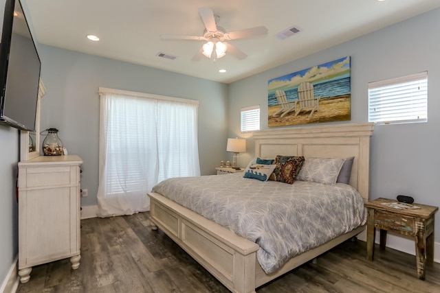 bedroom with multiple windows, dark hardwood / wood-style floors, and ceiling fan