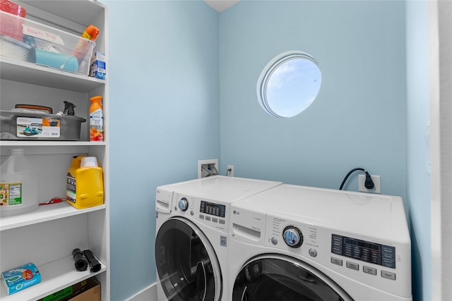 washroom featuring baseboards, laundry area, and separate washer and dryer