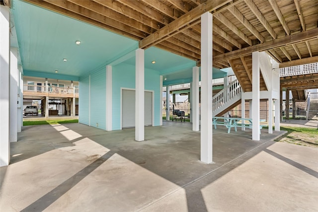 view of patio / terrace with fence, stairs, and a garage