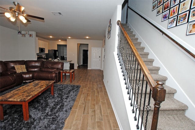 living room featuring wood-type flooring and ceiling fan