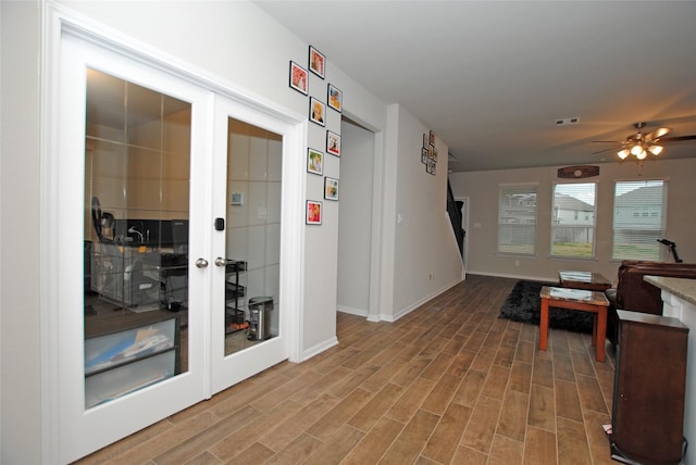 interior space with wood-type flooring, ceiling fan, and french doors