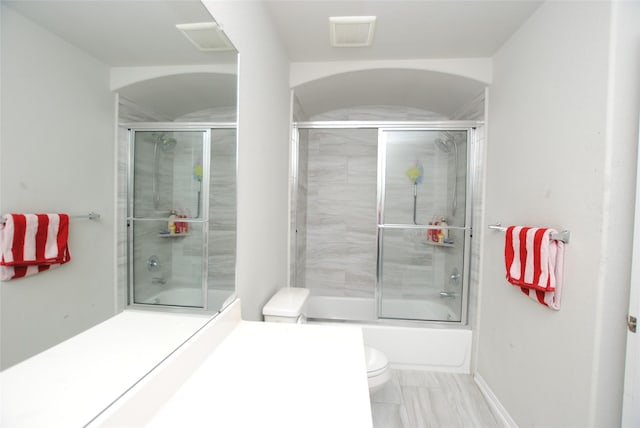 bathroom featuring enclosed tub / shower combo and toilet