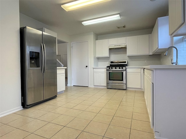 kitchen featuring light tile patterned flooring, appliances with stainless steel finishes, sink, and white cabinets