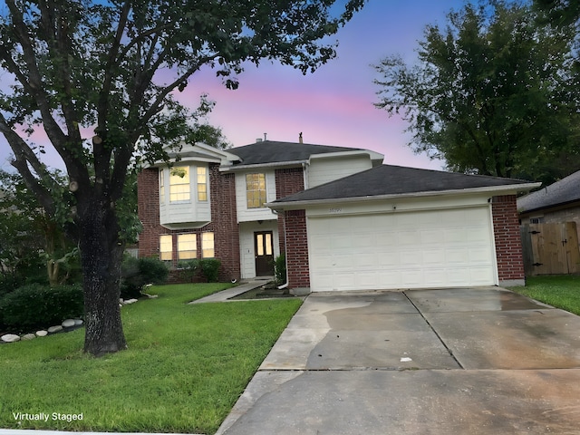 view of front of home with a garage and a yard