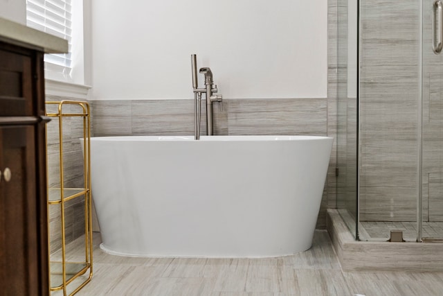 bathroom featuring tile walls and plus walk in shower