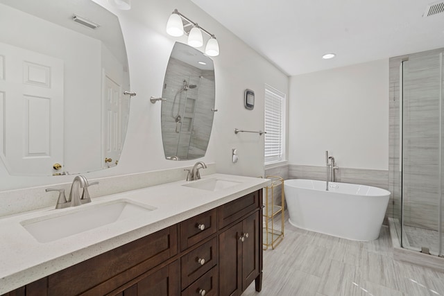 bathroom with vanity, independent shower and bath, and tile walls