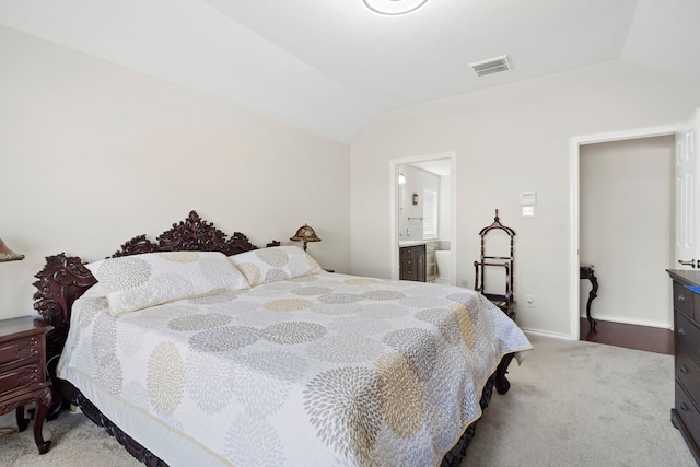 carpeted bedroom featuring ensuite bathroom and vaulted ceiling