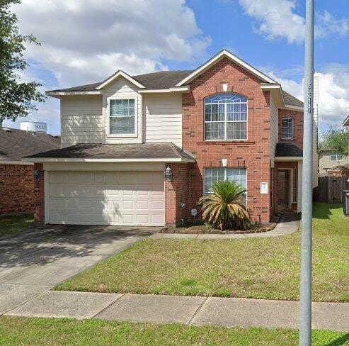 front of property with a garage and a front lawn